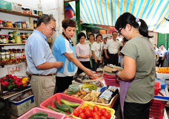 市建局董事会成员暨市建局中西区分区咨询委员会主席周光晖先生(左)、艺人肥妈(右)与一众嘉宾到访嘉咸街市集。