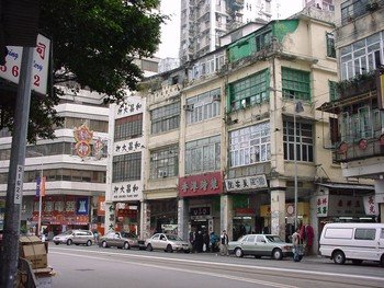 The four bays of shophouses form a continuous façade verandah.